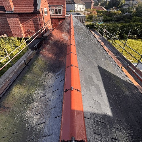 Dark slate-effect roof with a bright terracotta ridge running down the centre